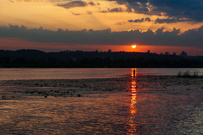 As the sun dips low behind the distant hills of Kyiv