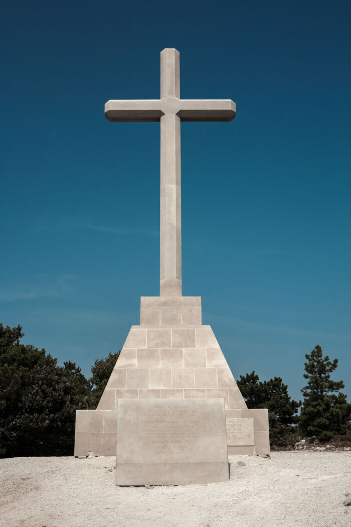 A tall stone cross stands solemnly against the horizon